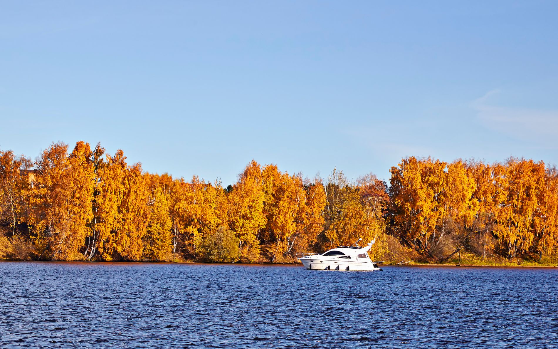 Bateau naviguant sous les lumières de l’automne